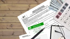 Tarjeta de identificación del IRS para el número ITIN, un bolígrafo negro, lentes y dinero en efectivo organizados para la preparación de impuestos.