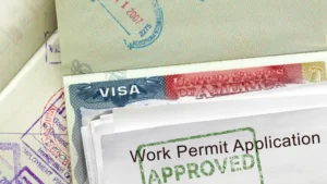 Pasaporte abierto con una visa americana y una solicitud de permiso de trabajo sellada como aprobada encima.