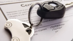 Llave de automóvil sobre un documento de certificado de seguro, representando servicios de seguros de vehículos y registro de autos.